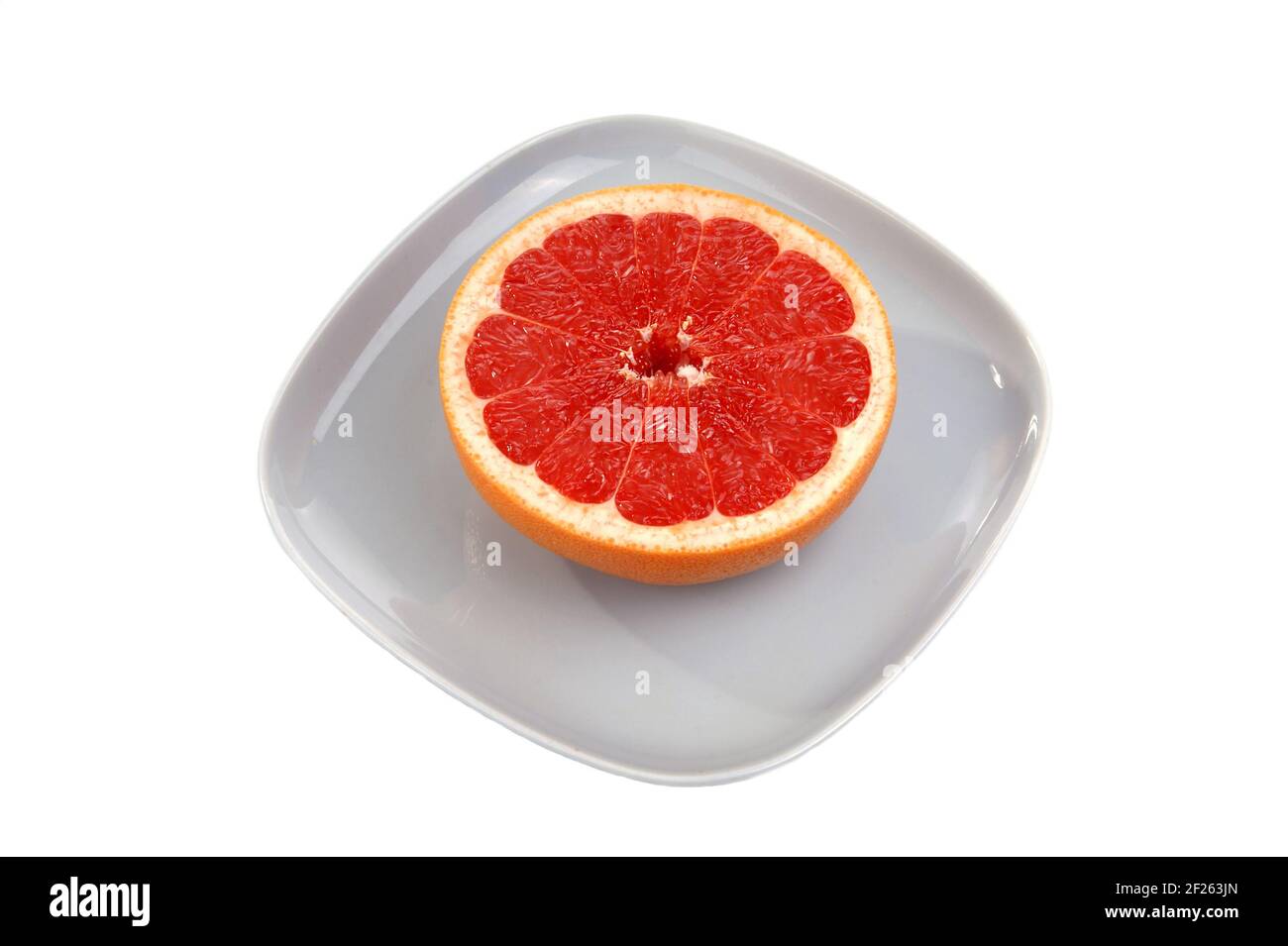 Ripe red grapefruit. The cut fruit on a blue plate Stock Photo