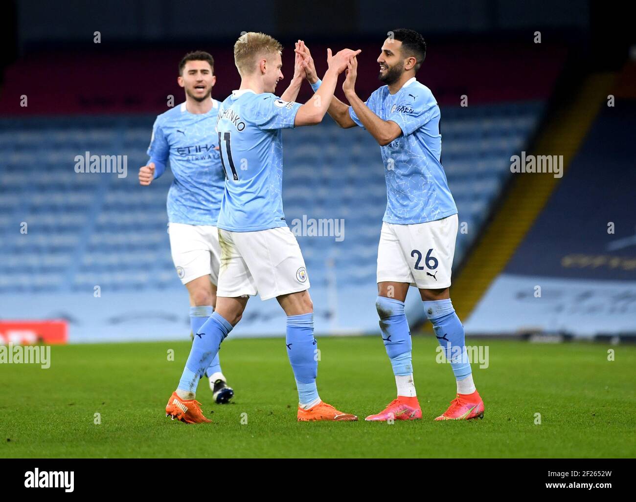 Manchester City's Riyad Mahrez (right) celebrates scoring their side's fourth goal of the game during the Premier League match at the Etihad Stadium, Manchester. Picture date: Wednesday March 10, 2021. Stock Photo