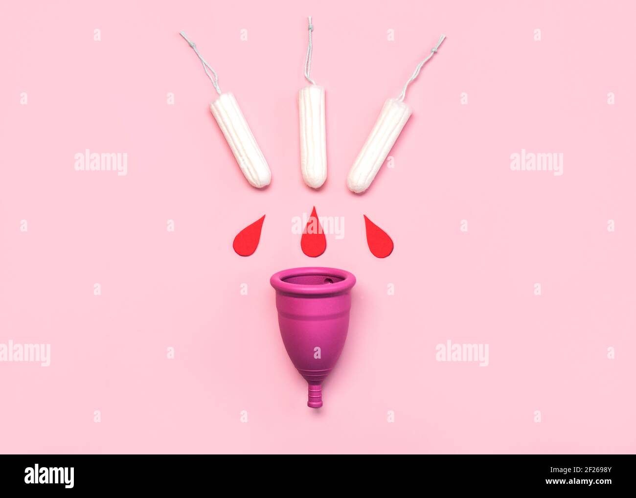 Silicone menstrual cup with tampons on pink background.Female intimate