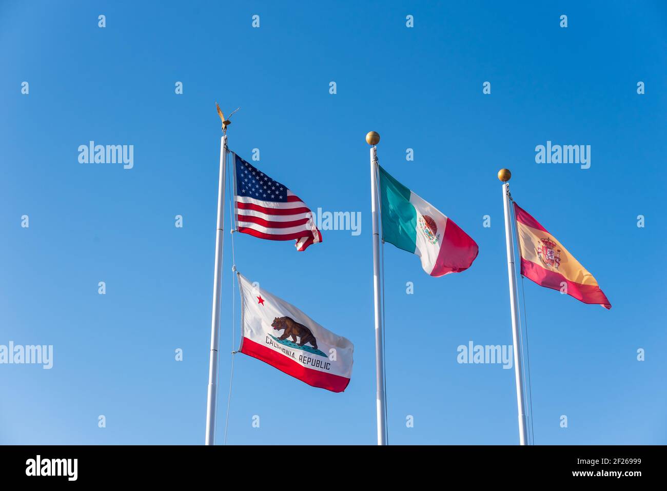 American, Mexico, and California state flags waving in the air. Stock Photo