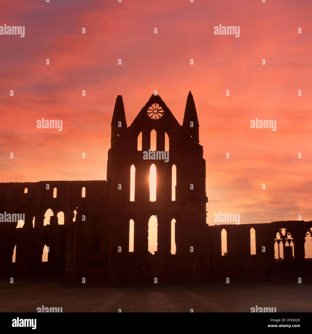 Historical 1995 sunset sky creating a silhouette archive view of part of the 1990s coastal landmark ruins at Whitby Benedictine Abbey a Grade I Listed building in the care of English Heritage a 90s archival history image in North Yorkshire England UK Stock Photo