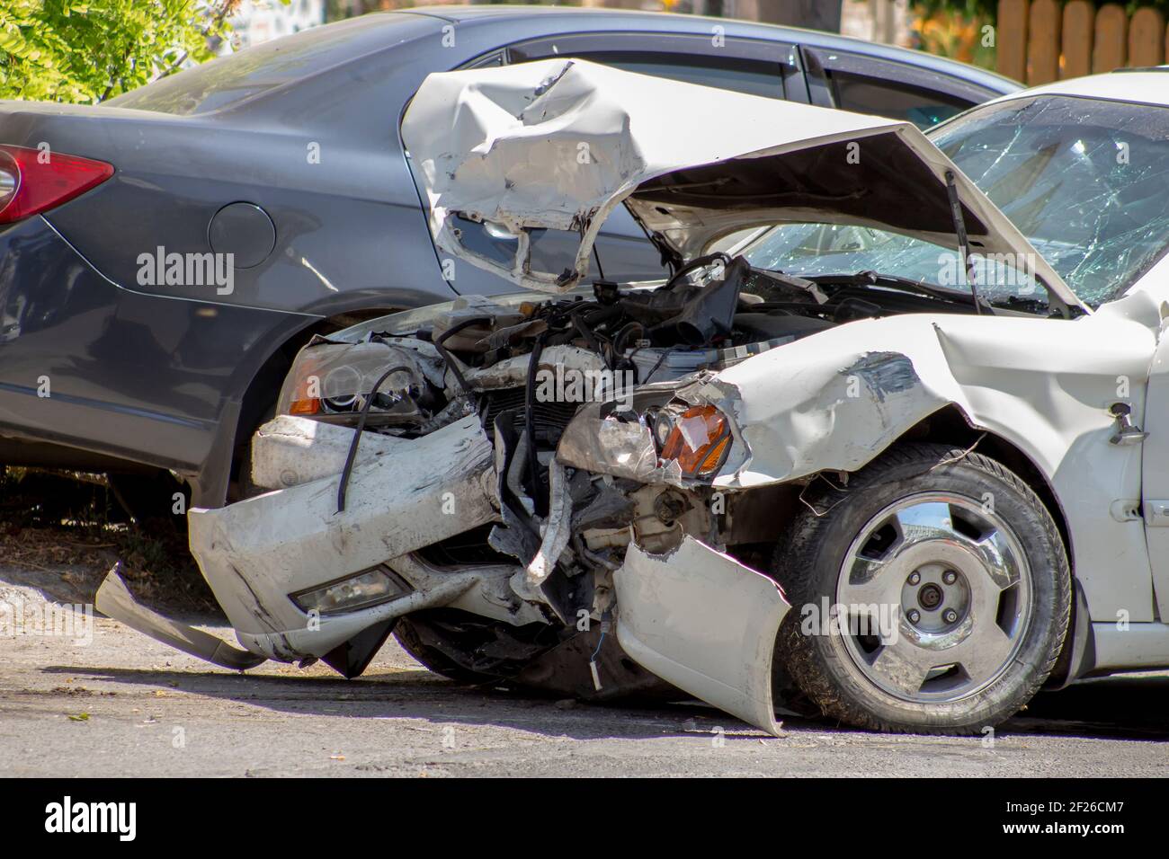 Wrecked white car on the road. Road accident, broken front of the car ...
