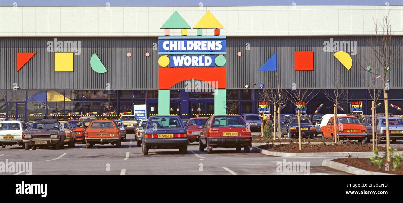 Historical 1987 archive shopping image of customers cars parked outside Childrens World a British retail business chain store founded by Boots in 1980s using a decorated superstore warehouse type shop building selling kids clothes shoes toys baby products & nursery furniture located in a retail park at Thurrock illustrating an archival view of the way we were at Christmas time in 80s Essex England UK Stock Photo