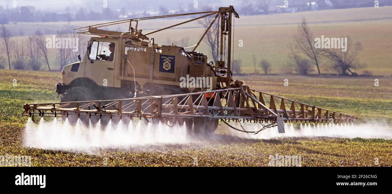 Historical 1988 spring countryside archive image of Mercedes lorry truck fitted with 80s agriculture crop spraying equipment farmer driver working on a sloping farmland field in archival rural Essex landscape being the way we were in 1980s Mountnessing Brentwood England UK Stock Photo