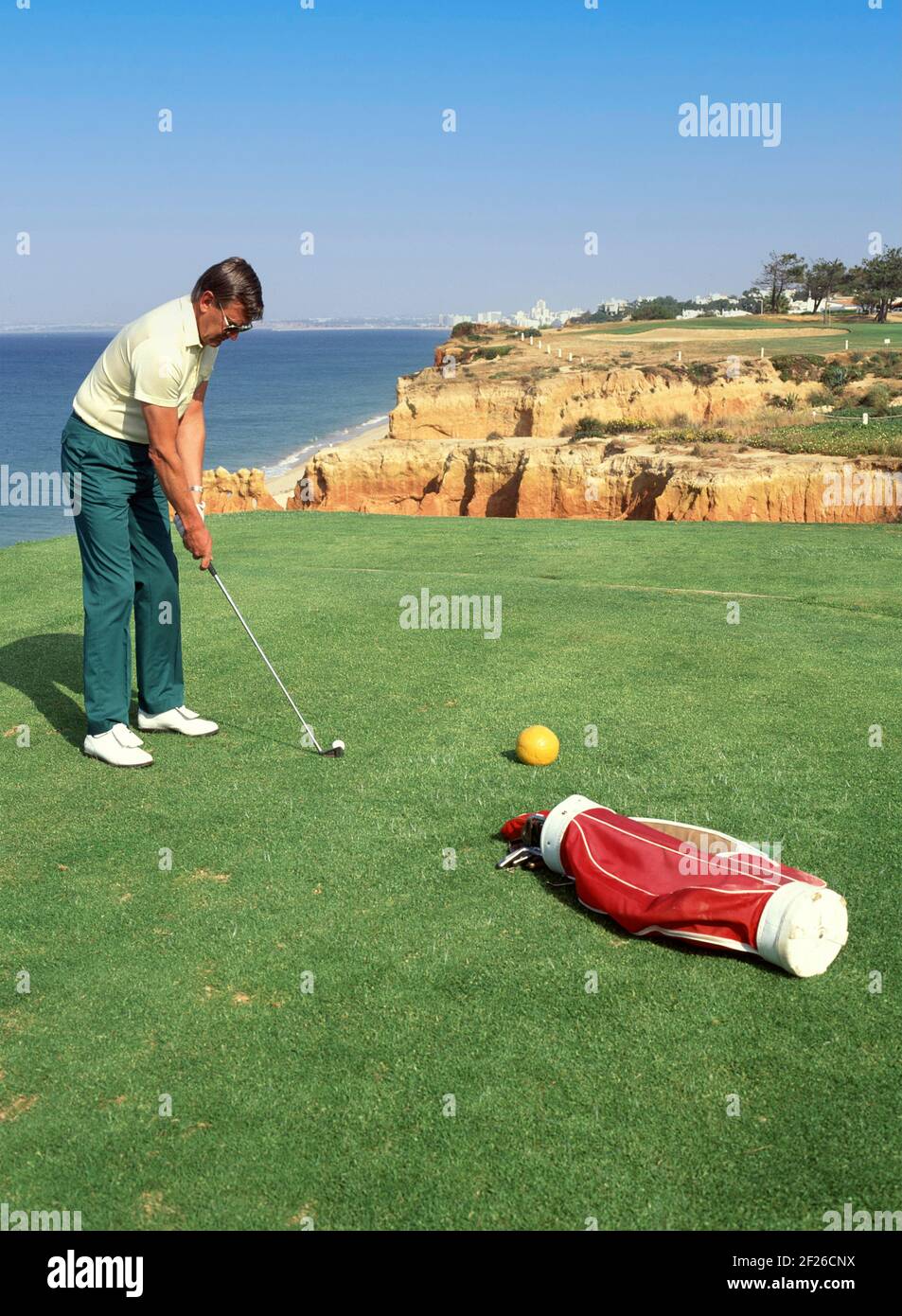 Historical 1992 sport archive view of professional golfer player on the green at Vale do Lobo golf course in the 90s the famous cliff top hole beside ravines & Algarve beaches model released man playing golf the way we were in an archival travel image in Portugal in the 1990s Stock Photo