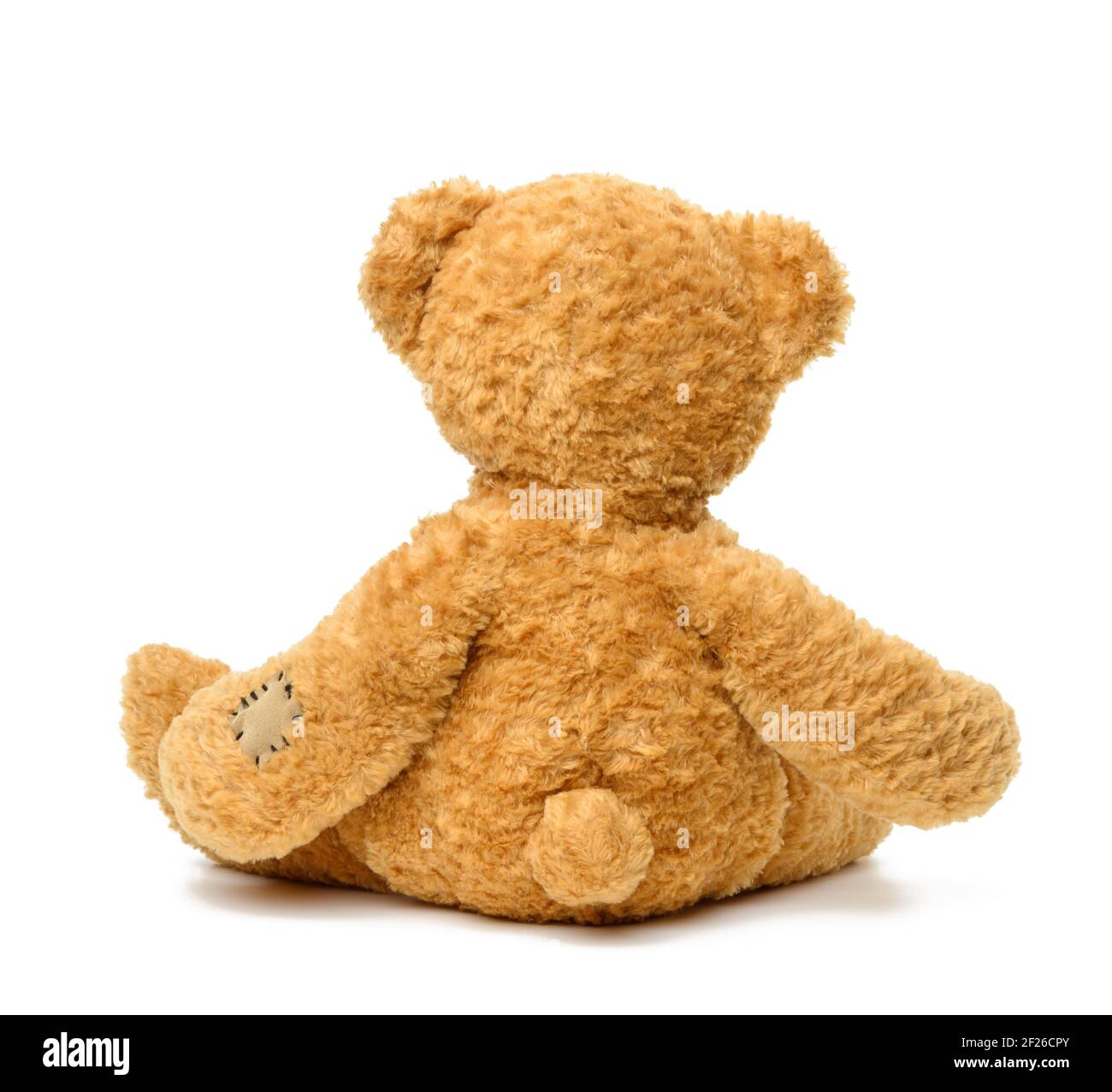 Brown teddy bear sitting back on white isolated background Stock Photo