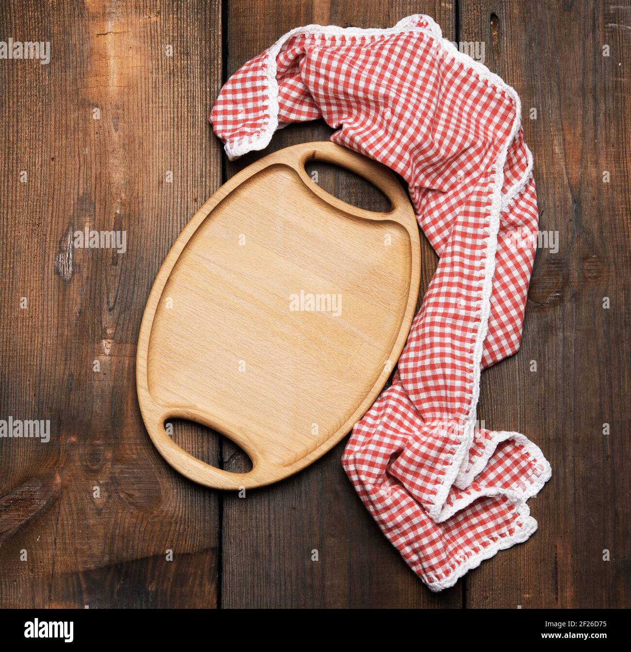 Empty oval brown wooden tray board on a wooden background Stock Photo