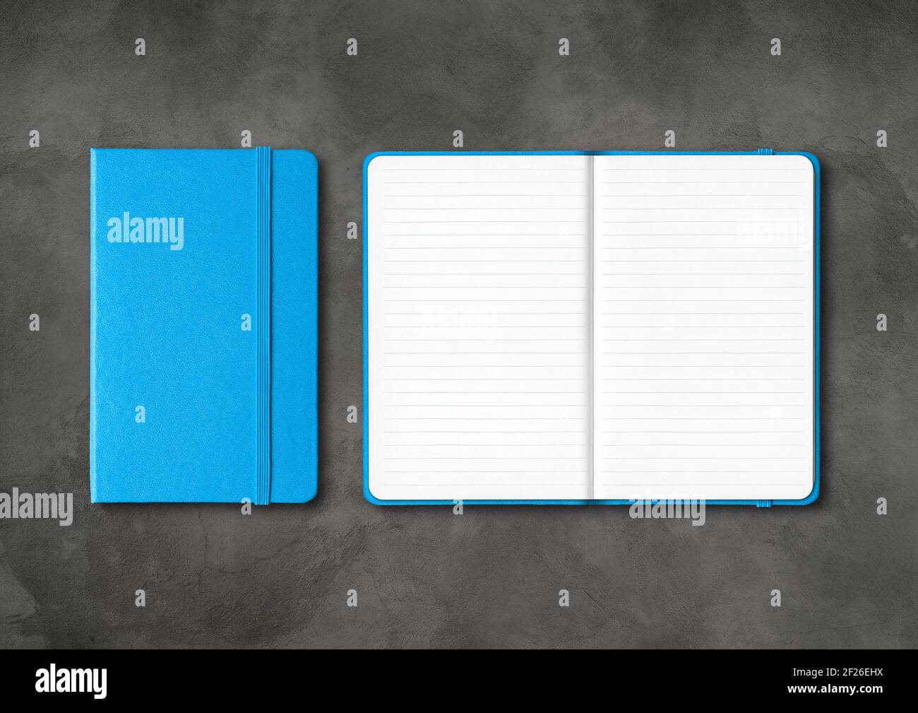 Blue closed and open lined notebooks on dark concrete background Stock Photo