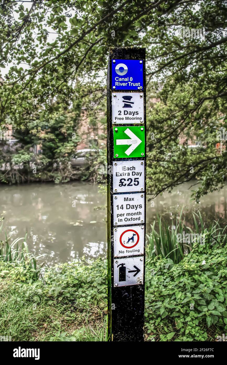 7-27-2019 Oxford UK - Canal & River Trust sign along the Oxford Canal tow path with costs and rules for mooring and dogs Stock Photo