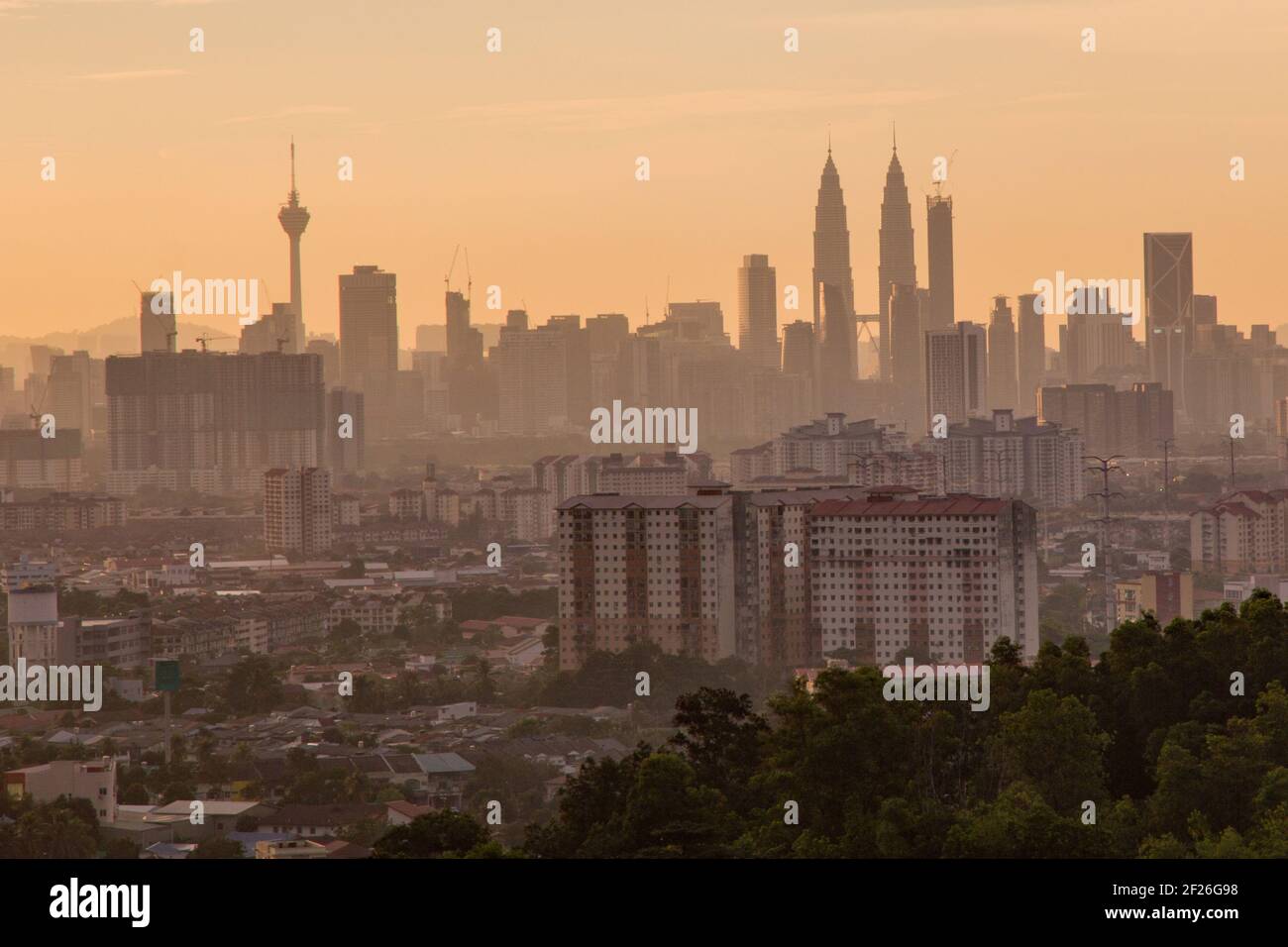 Kuala Lumpur cityscape at golden hour taken from a high viewpoint over looking the business district of the city and surrounding suburbs and hills Stock Photo