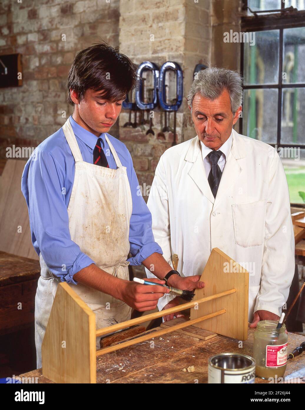 Teacher and male pupil in woodworking class, Surrey, England, United Kingdom Stock Photo