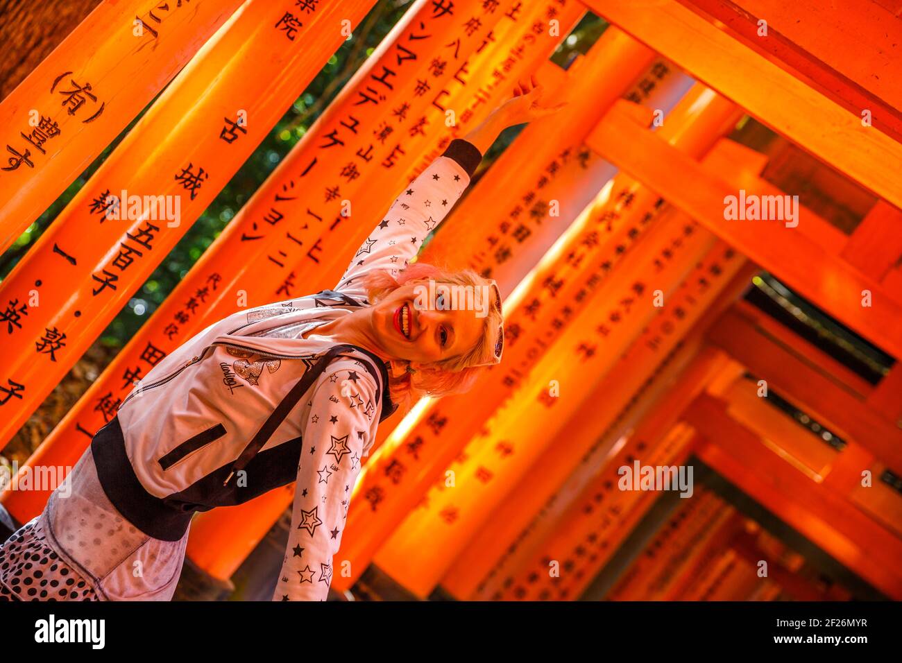 Kyoto, Japan - April 28, 2017: Torii tunnel path. Back of woman walking ...