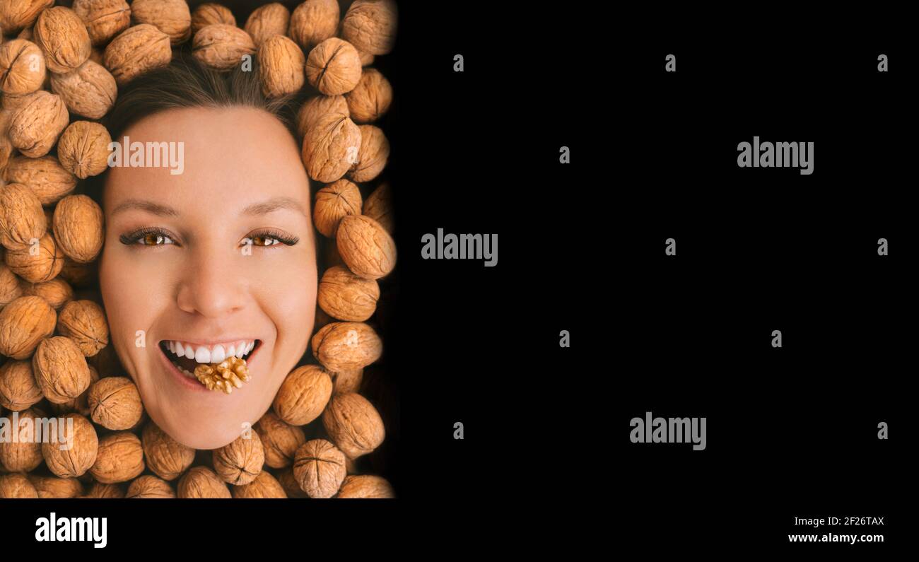 Happy woman face with perfect smile on a walnuts background with copy space Stock Photo