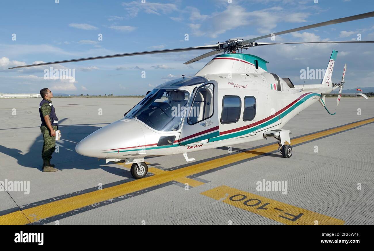 Mexican soldier stands in front of an Agusta Grand helicopter at Queretaro airport, Mexico Stock Photo