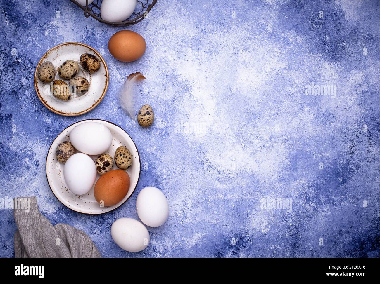 Quail and chicken eggs on blue background Stock Photo