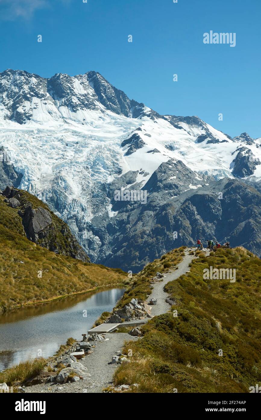 Hikers by Sealy Tarns, and Mt Sefton, Aoraki / Mount Cook National Park, South Island, New Zealand Stock Photo