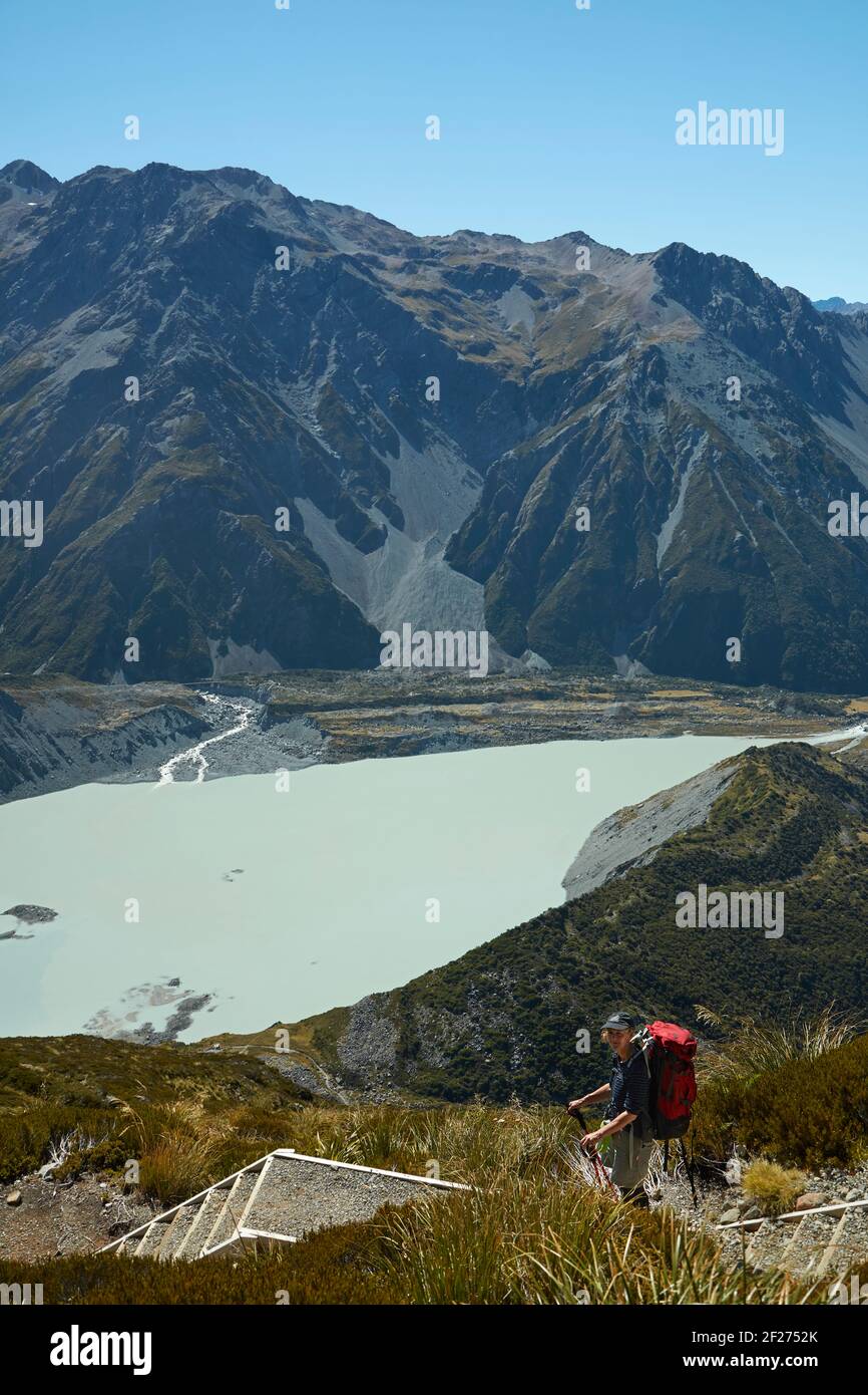 Hiker above Mueller Lake on track to Sealy Tarns and Mueller Hut, Aoraki / Mount Cook National Park, South Island, New Zealand  (model released) Stock Photo