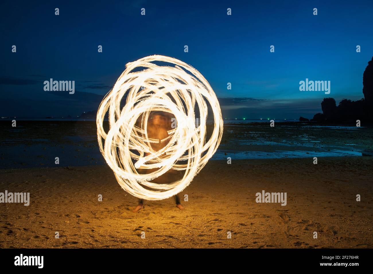 Fire dancer performing on the beach in Railay Stock Photo