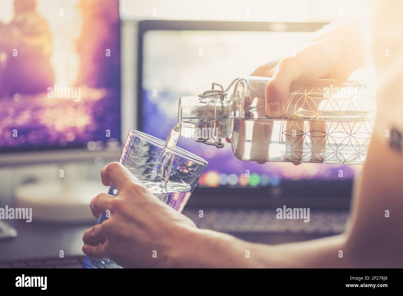 Drinking water in the office: close up of glass bottle, workplace Stock Photo