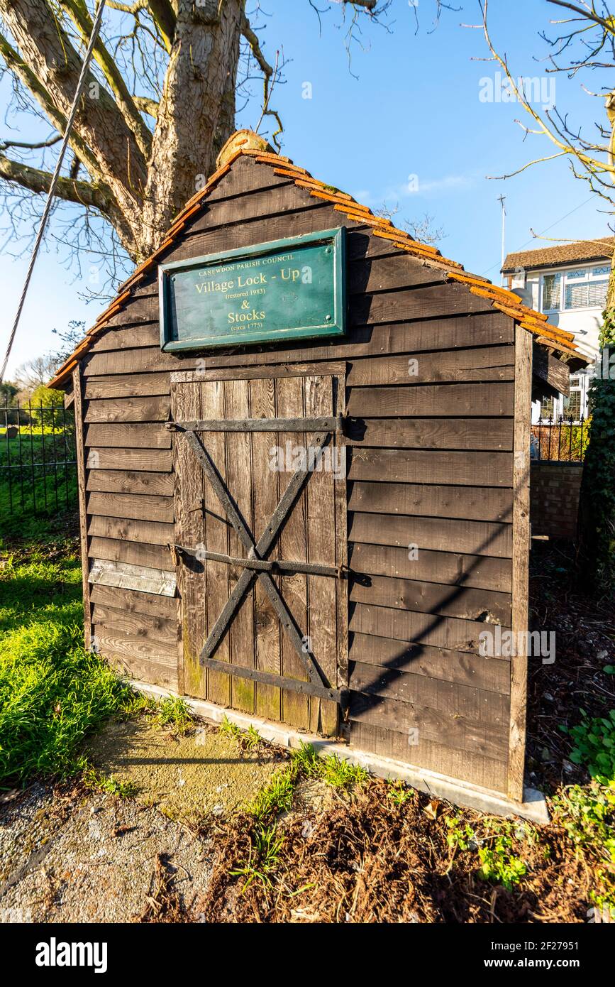 Wooden lock up and stocks building by Church of St. Nicholas parish church in Canewdon, Essex, UK. Early temporary detention prison for criminals Stock Photo