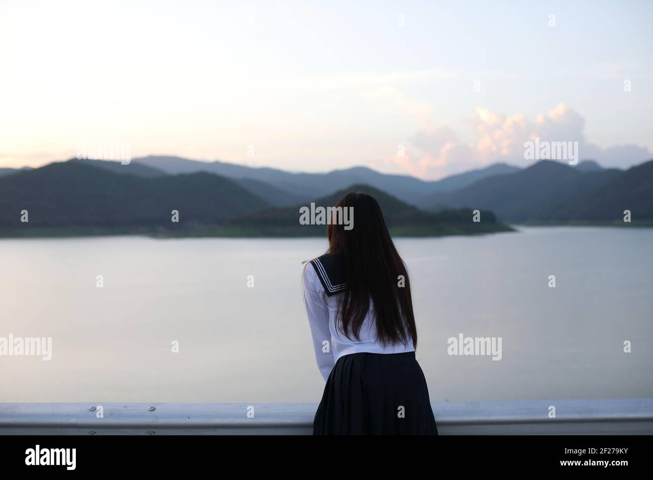 Asian school girl looking mountain with river in sunrise Stock Photo