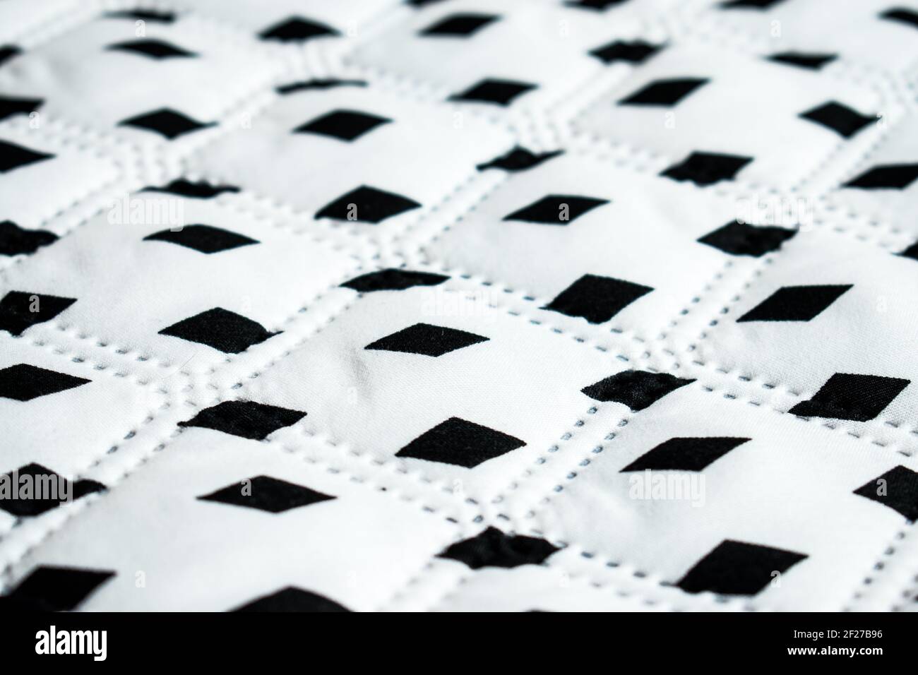 White, big and soft surface with some black rhombuses in a straight line Stock Photo