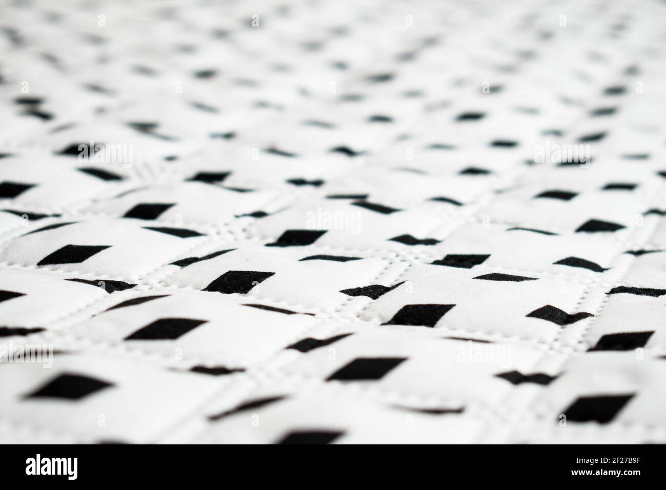 White, big and soft surface with some black rhombuses in a straight line Stock Photo