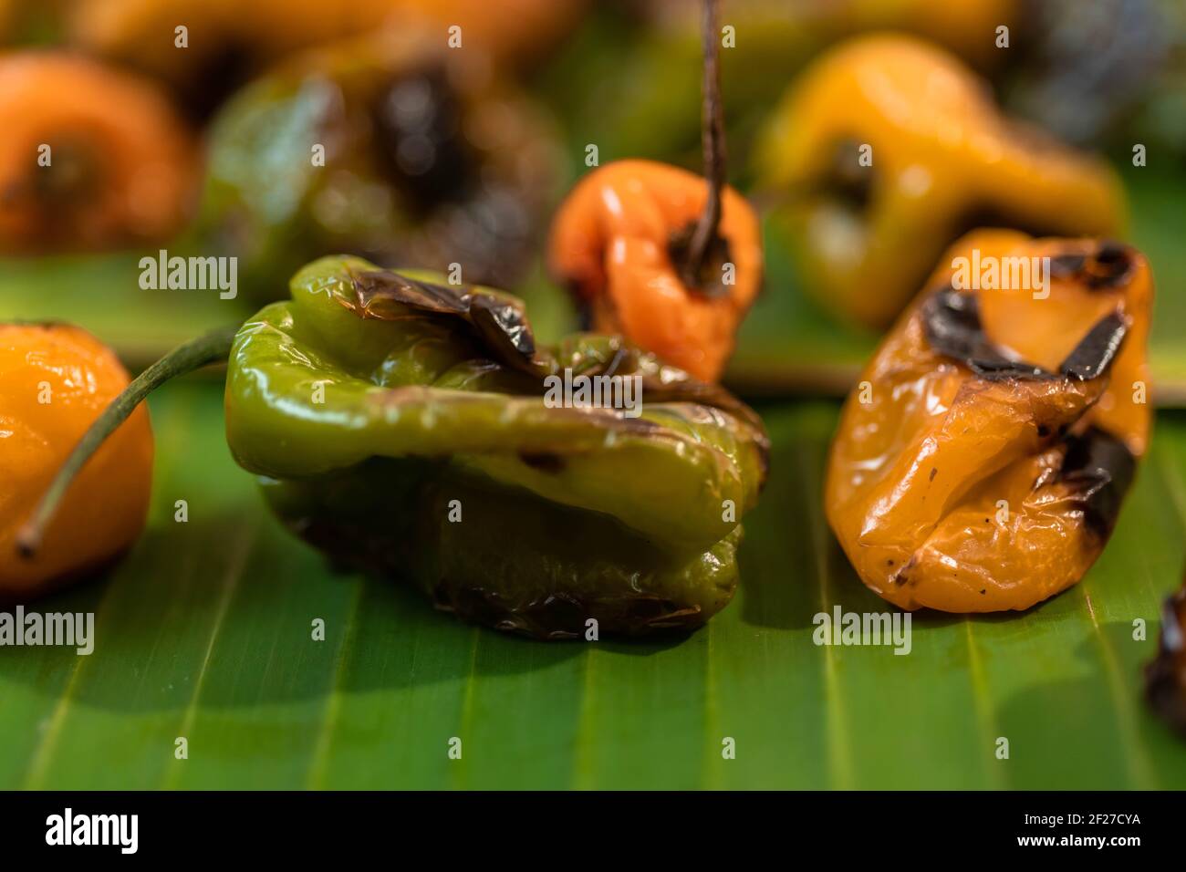 Closeup shot of grilled tasty bell peppers on a green surface, lightly burned habanero peppers for spicy Mexican sauce Stock Photo