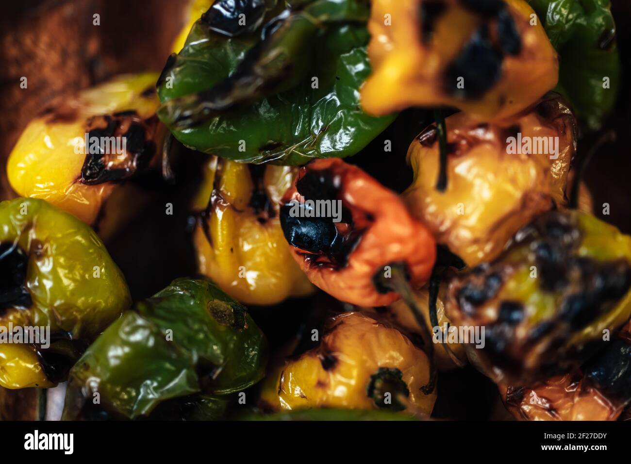 Closeup shot of grilled tasty bell peppers on a green surface, lightly burned habanero peppers for spicy Mexican sauce Stock Photo
