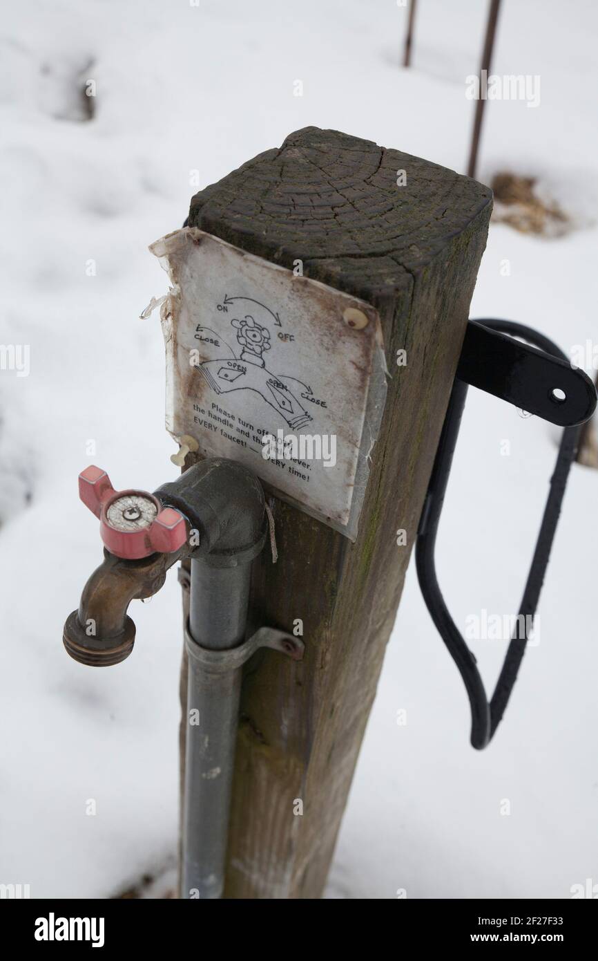 Communal water faucet in a New England community garden in the winter. Stock Photo