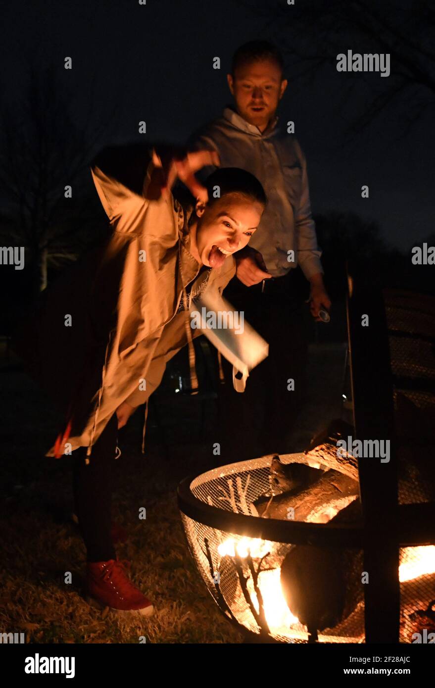 Dallas, United States. 10th Mar, 2021. Attendees at a 'Texas is Now Open' party throw their masks into a fire on Wednesday, March 10, 2021, in Parker, Texas. The event also included a moment of silence for those who have lost their lives to COVID-19. Texas governor Greg Abbott fully rescinded the statewide mask order and is allowing business to reopen at full capacity. Photo by Ian Halperin/UPI. Credit: UPI/Alamy Live News Stock Photo