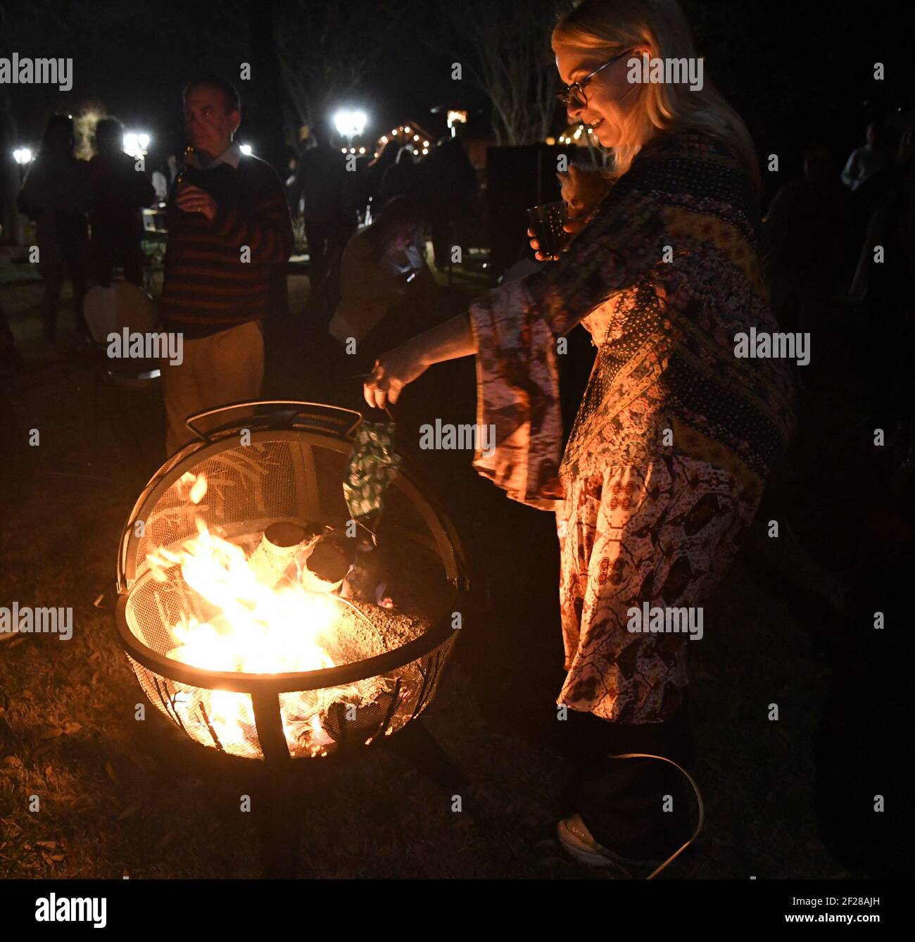 Dallas, United States. 10th Mar, 2021. Attendees at a 'Texas is Now Open' party throw their masks into a fire on Wednesday, March 10, 2021, in Parker, Texas. The event also included a moment of silence for those who have lost their lives to COVID-19. Texas governor Greg Abbott fully rescinded the statewide mask order and is allowing business to reopen at full capacity. Photo by Ian Halperin/UPI Credit: UPI/Alamy Live News Stock Photo