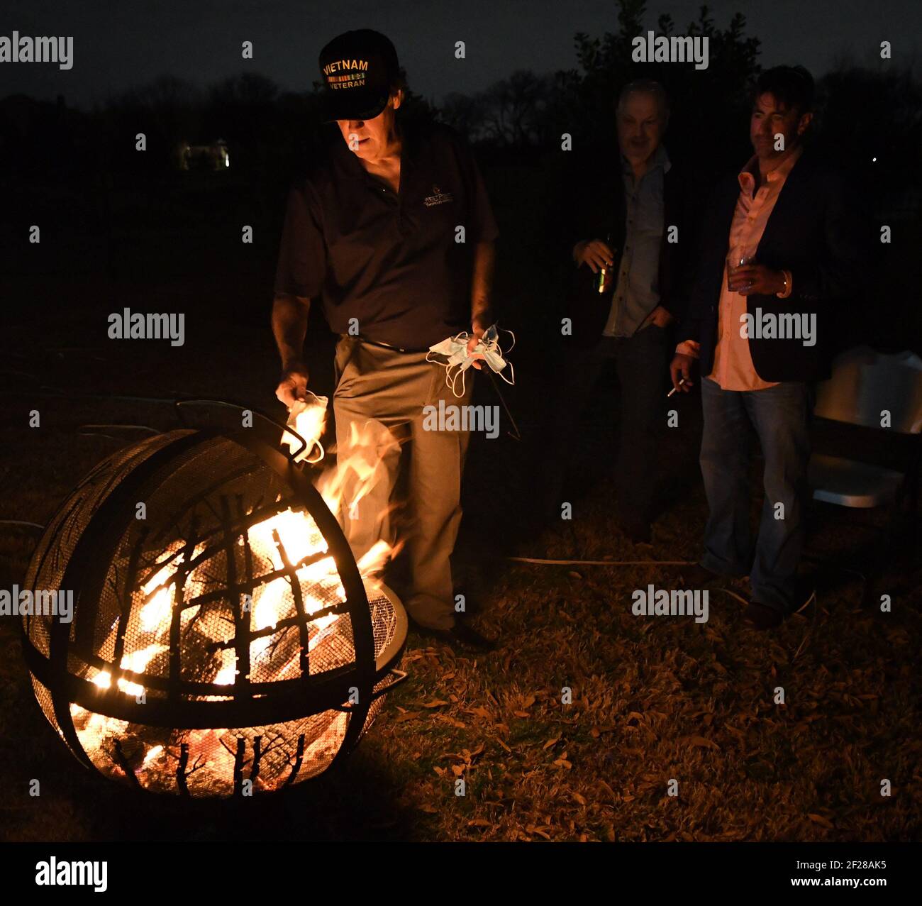 Dallas, United States. 10th Mar, 2021. Attendees at a 'Texas is Now Open' party throw their masks into a fire on Wednesday, March 10, 2021, in Parker, Texas. The event also included a moment of silence for those who have lost their lives to COVID-19. Texas governor Greg Abbott fully rescinded the statewide mask order and is allowing business to reopen at full capacity. Photo by Ian Halperin/UPI Credit: UPI/Alamy Live News Stock Photo