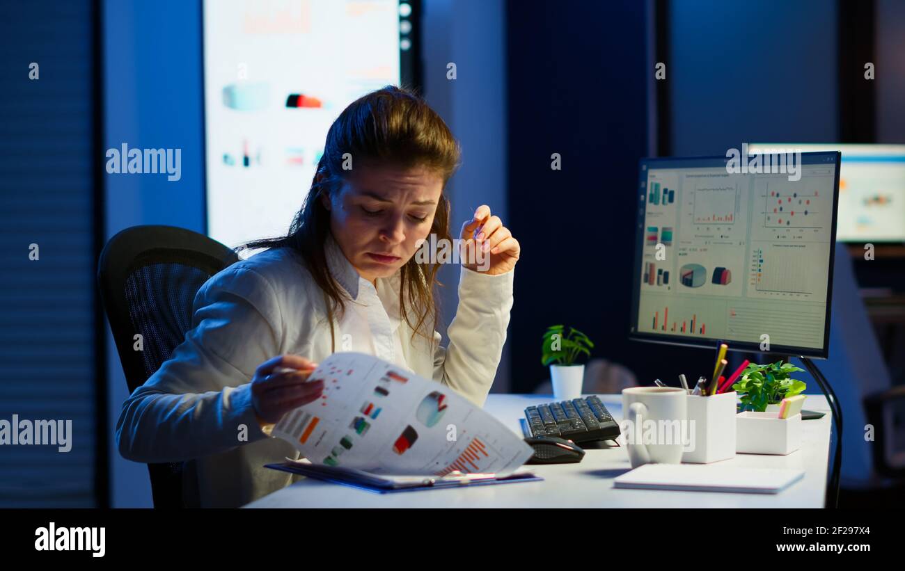 Tired freelancer comparing graphics from clipboard and computer working ...