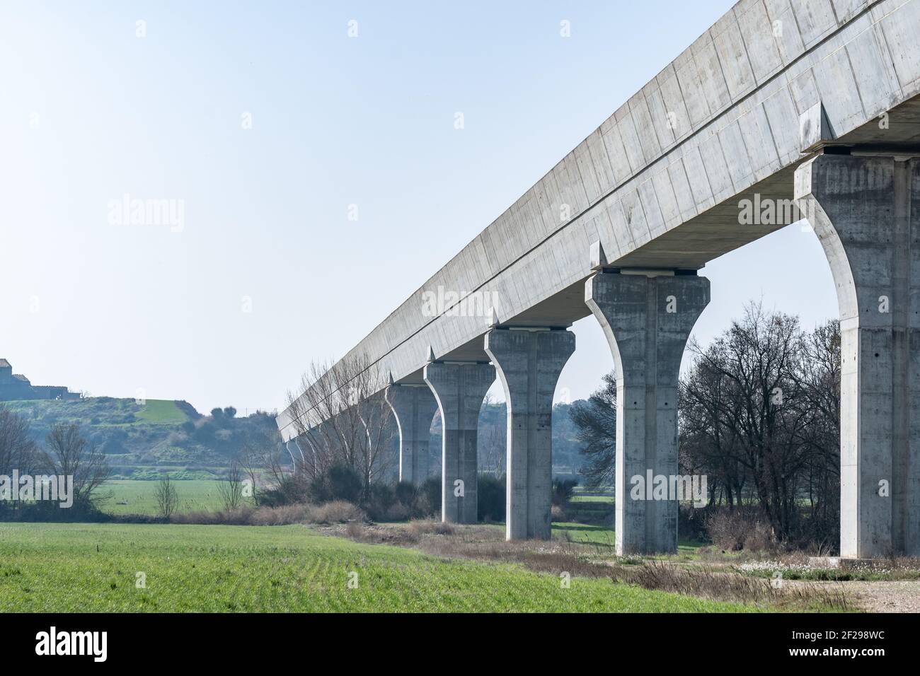 Lower view of a modern aqueduct with its concrete pillars. Civil engineering work. Water transport infrastructure Stock Photo