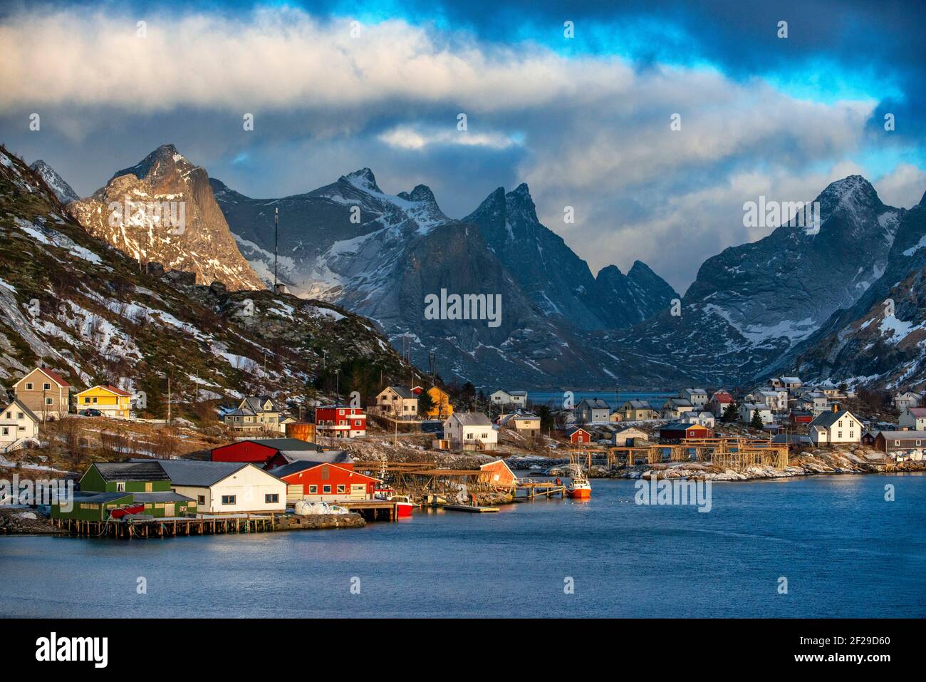 View across the natural fishing harbour to towering mountains above Reine, Moskenes, Moskenesøya Island, Lofoten Islands, Norway Stock Photo