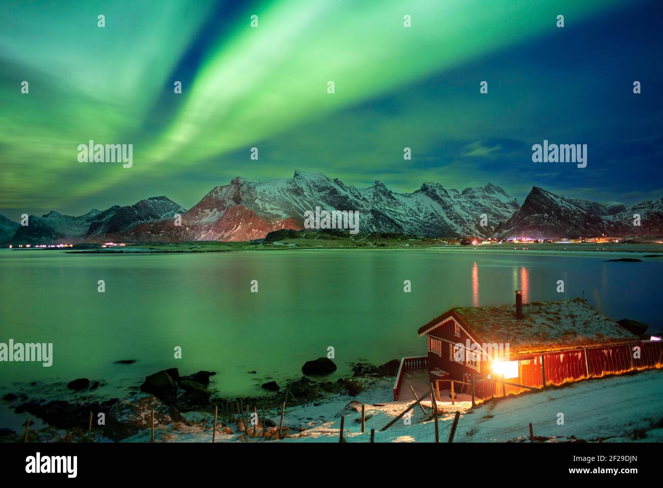 Northern lights or Aurora Borealis over atypical red houses rorbu, Svolvaer Lofoten Norway Stock Photo