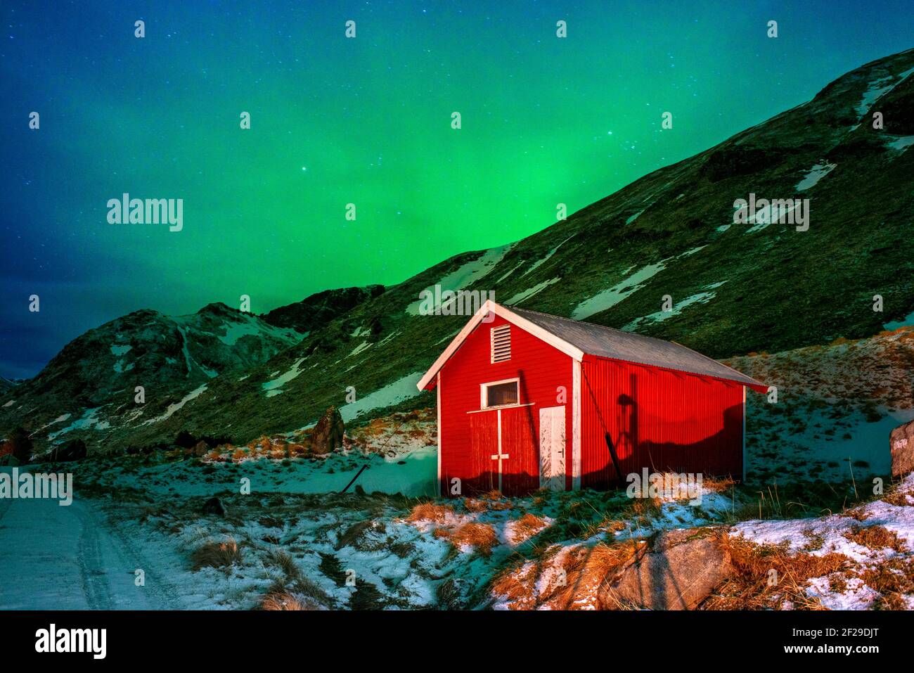 Northern lights or Aurora Borealis over atypical red houses rorbu, Svolvaer Lofoten Norway Stock Photo