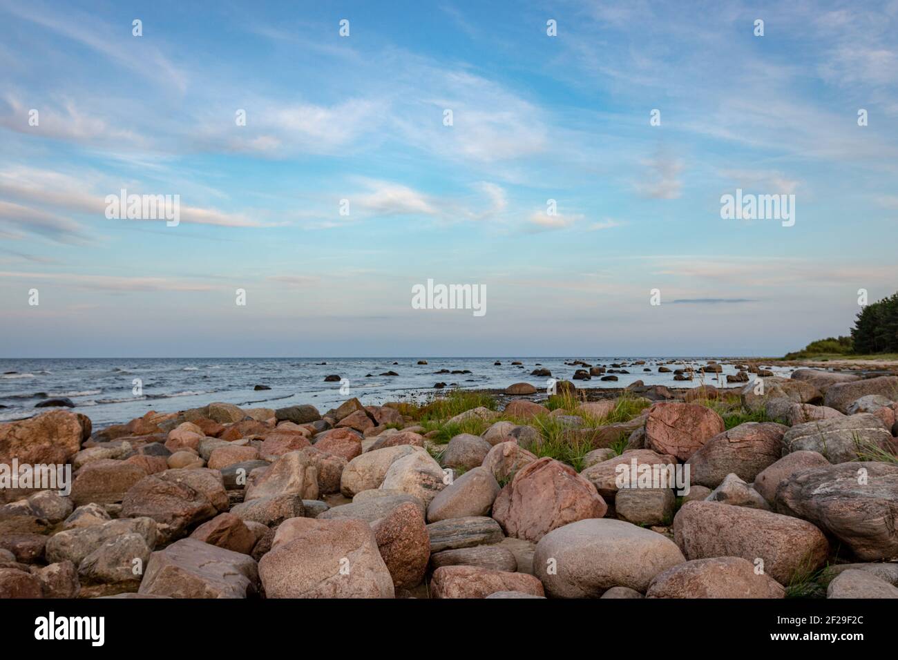 blue evening evening sun , sunset over sea, rocky sea shore, Baltic sea, Riga gulf Stock Photo