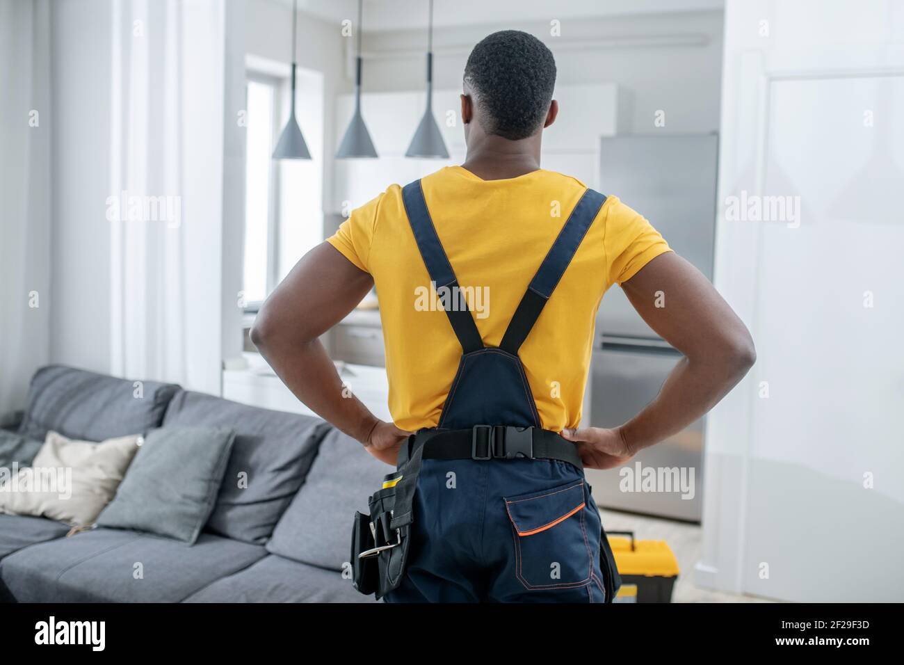 Service Man Images Dark-skinned service man in yellow tshirt standing in the kitchen Stock ...
