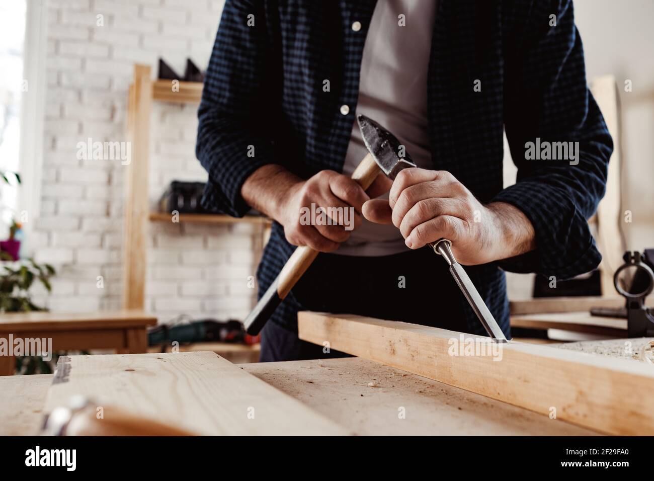 Hands of a carpenter working with chisel and hammer Stock Photo - Alamy