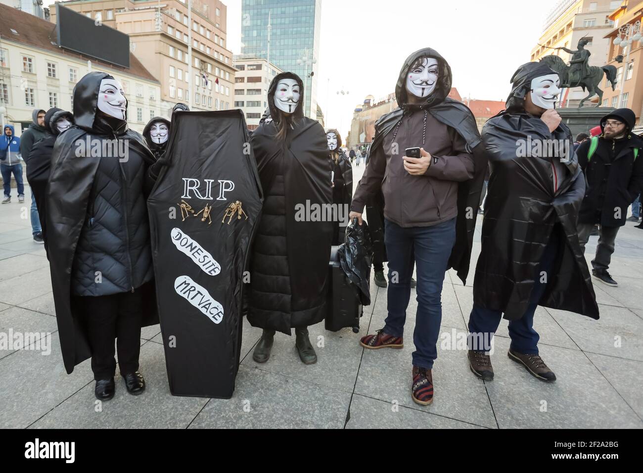 A group of citizens for freedom held a performance against the government and measures with masks anonymous and a coffin on which it says RIP bring th Stock Photo