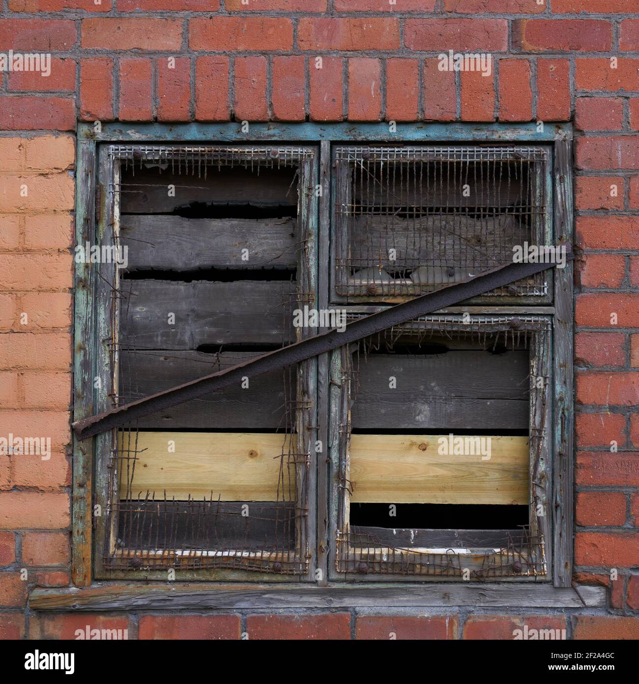 Old window frame in an industrial unit under a railway bridge Stock Photo