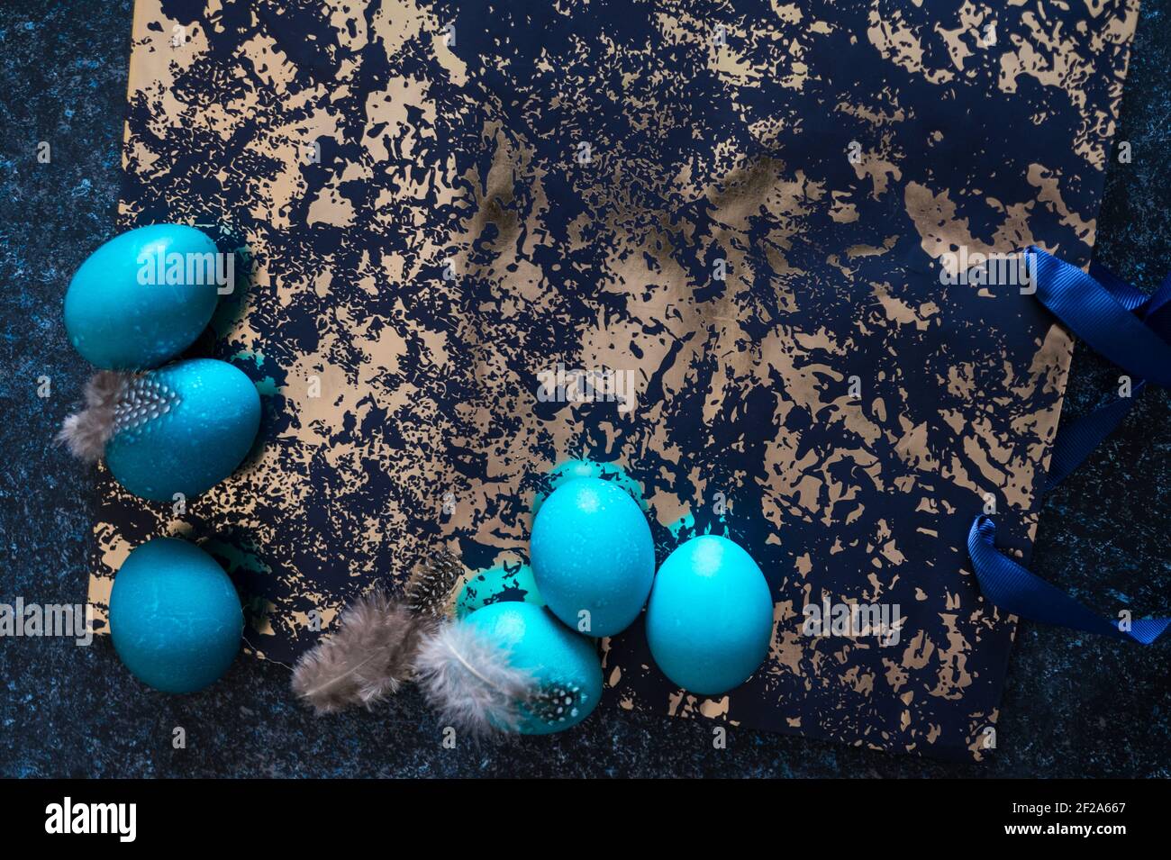 Mystical coloring Easter eggs with twigs on blue background. Background with copy space. Selective focus Stock Photo