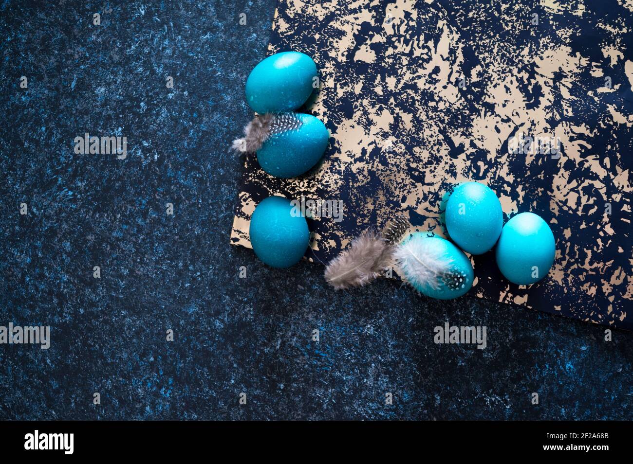 Mystical coloring Easter eggs with twigs on blue background. Background with copy space. Selective focus Stock Photo