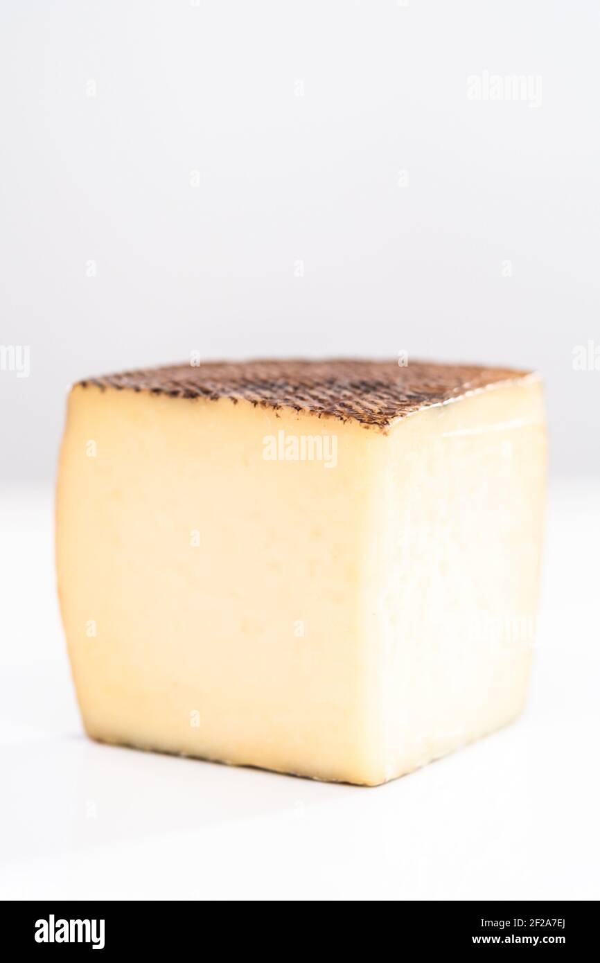 Large slice of aged Manchego cheese on a white background Stock Photo ...