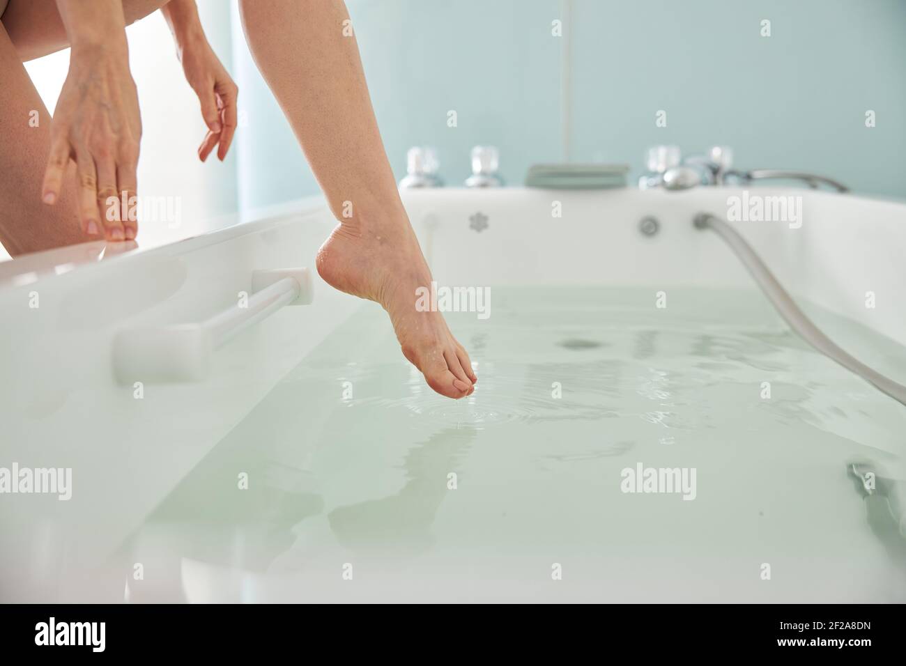 Person putting a leg in a spa bath with water Stock Photo - Alamy