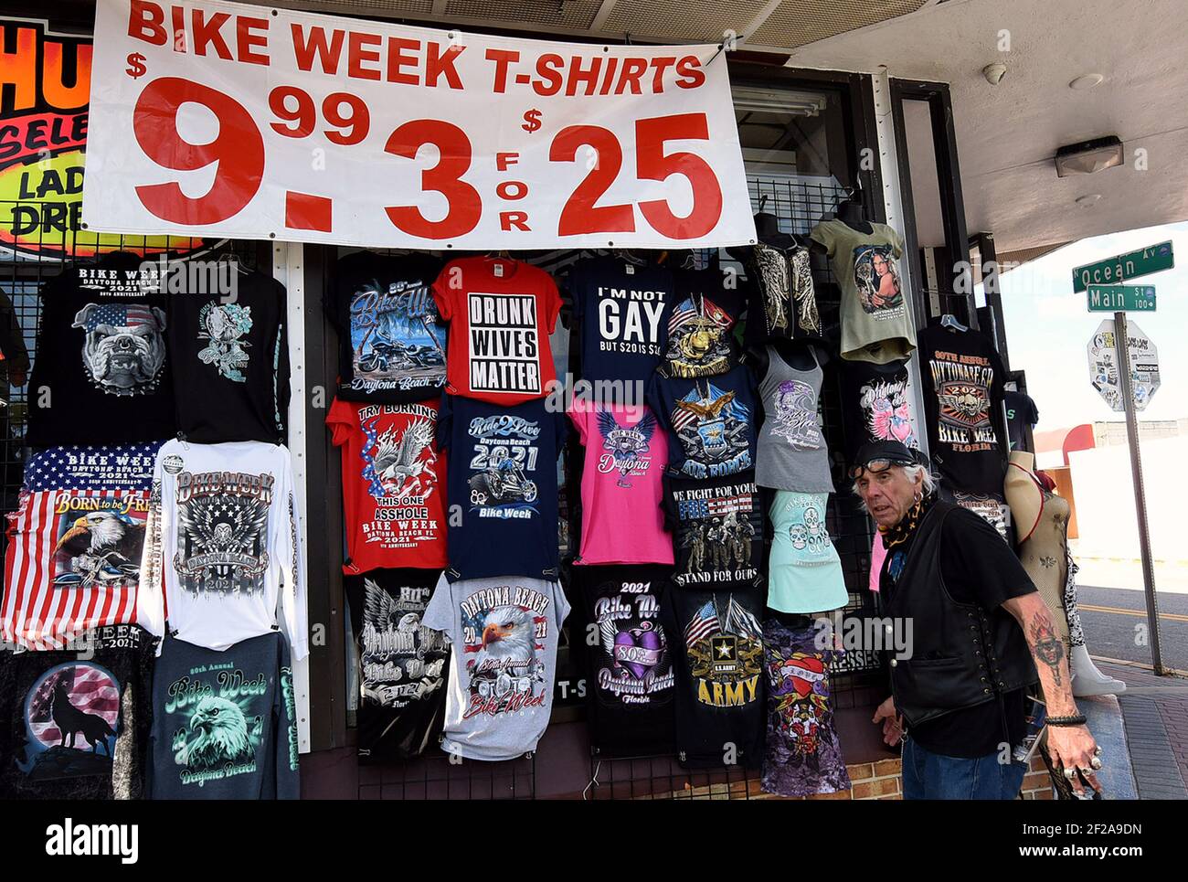 A man walks past a t-shirt display on Main Street during the 80th year of Daytona Beach's annual Bike Week event. Few people were seen wearing face masks or practicing social distancing and some worry the gathering could become a superspreader event as the coronavirus pandemic continues. (Photo by Paul Hennessy / SOPA Images/Sipa USA) Stock Photo
