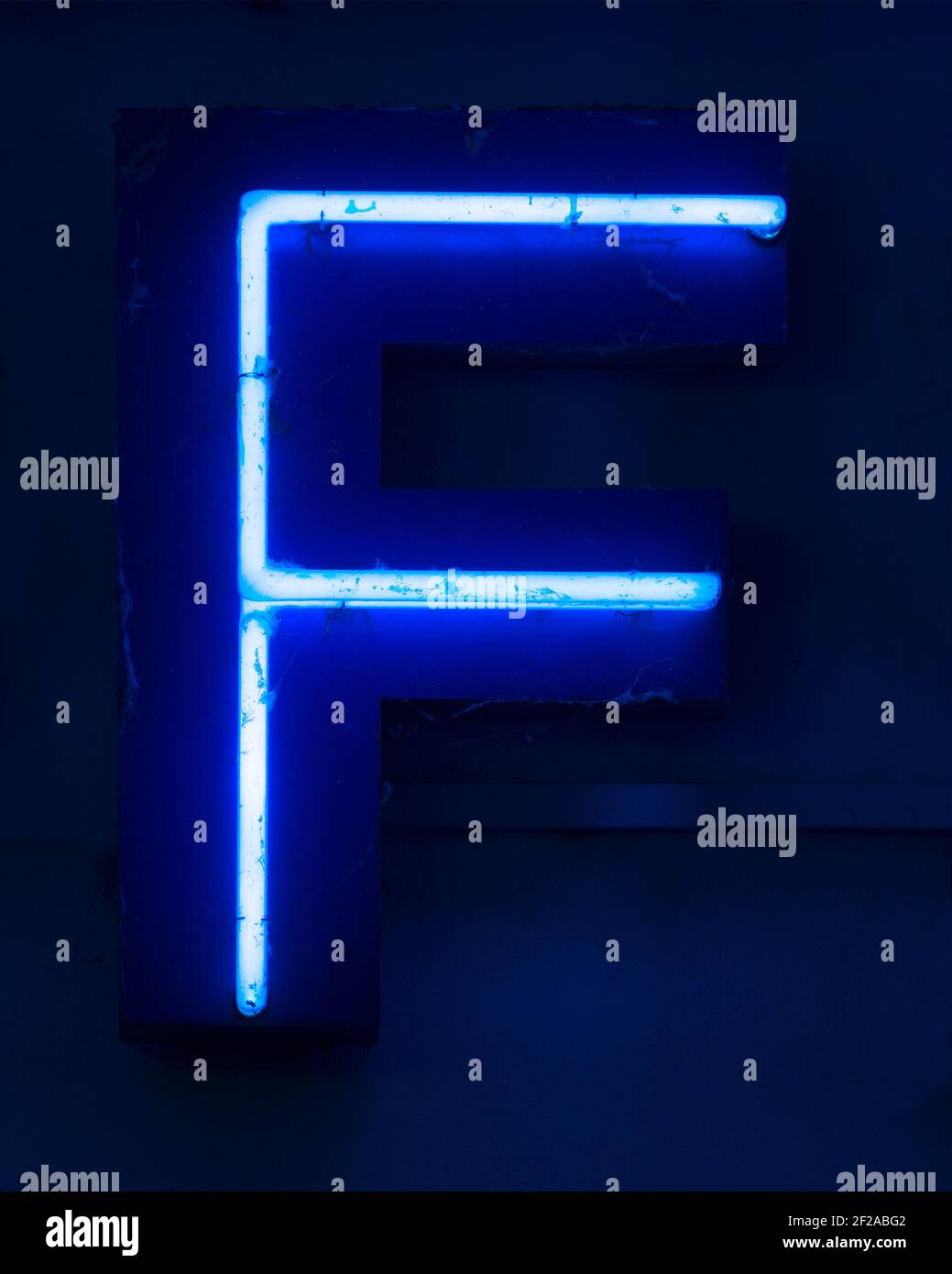 Blue shining neon letter F at night Stock Photo
