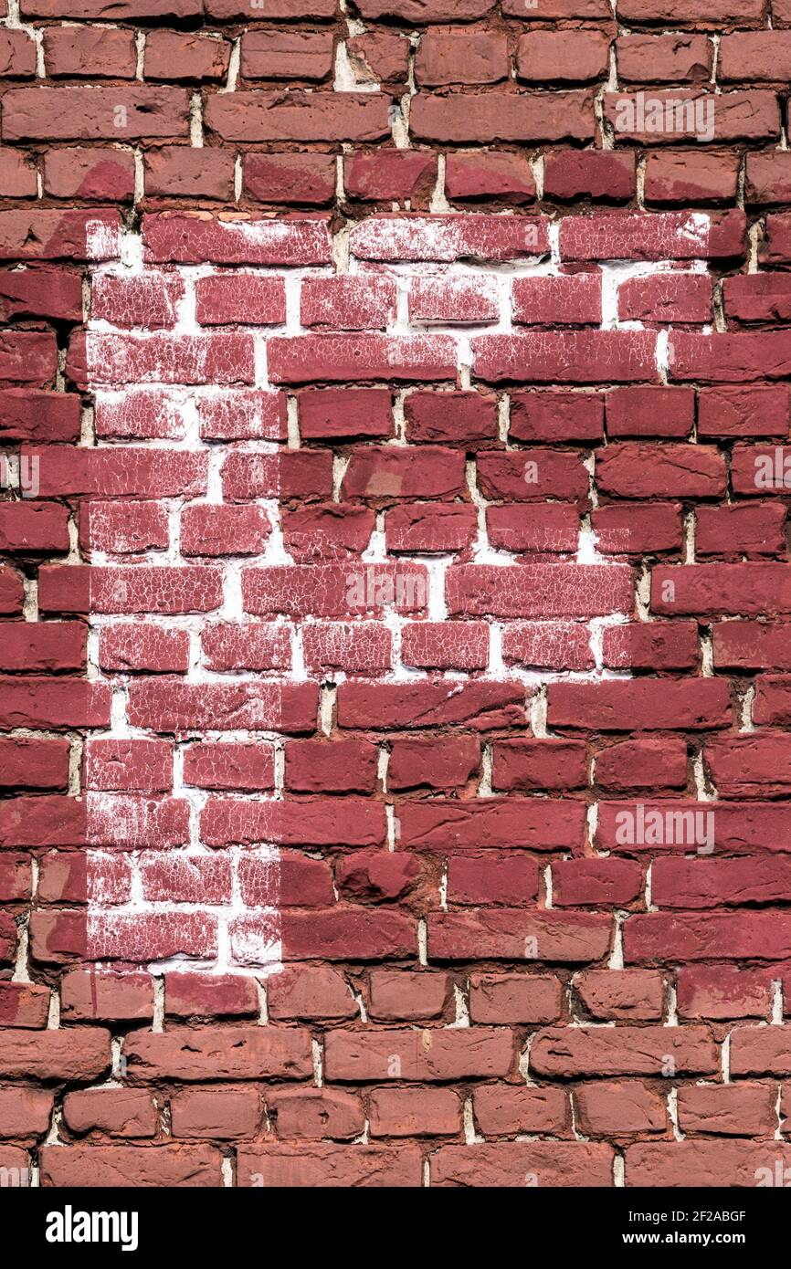 The letter F painted white on a red brick wall Stock Photo